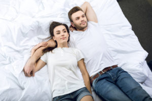 мужчина и девушка лежат на кровати