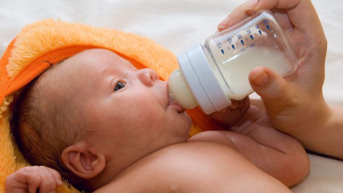 ребенок пьет молочко из бутылочки
